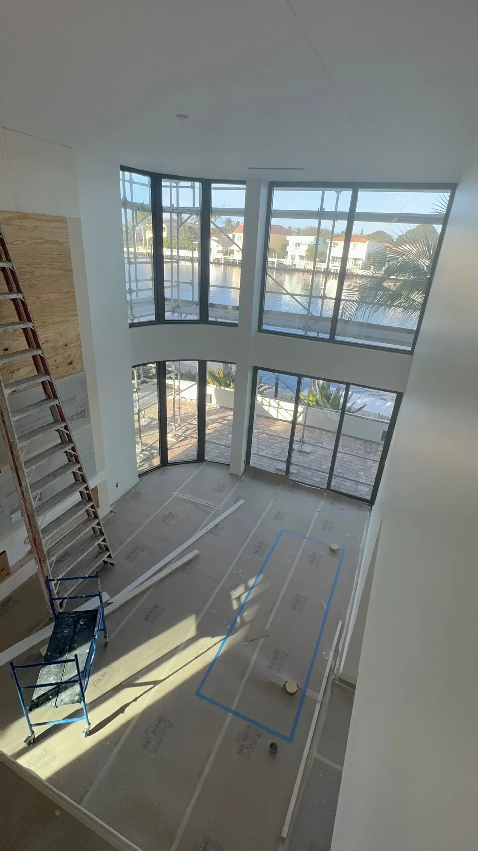 Double height great room during construction with the floor covered