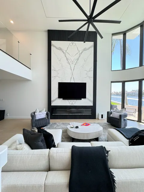 Light wide plank floor in a double height great room with a stone feature wall