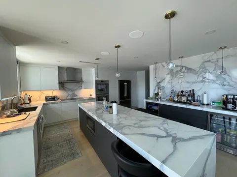 Kitchen with a waterfall island over wide plank flooring