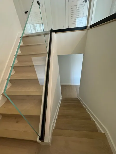Stair treads and risers finished to match the main floor, with a glass rail