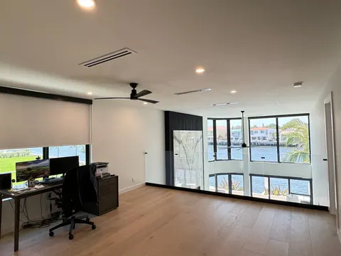 Loft office with wide plank flooring and a waterway view