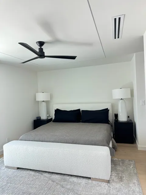 Primary bedroom on light wide plank flooring